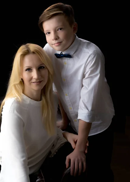 Mamma e figlio adolescente su uno sfondo nero . — Foto Stock