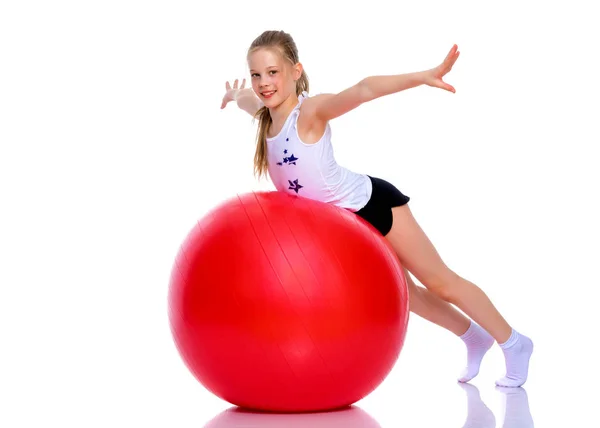 Niña haciendo ejercicios en una pelota grande para la aptitud. — Foto de Stock