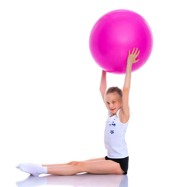 Mała dziewczynka robi ćwiczenia na dużą piłkę do fitness. — Zdjęcie stockowe