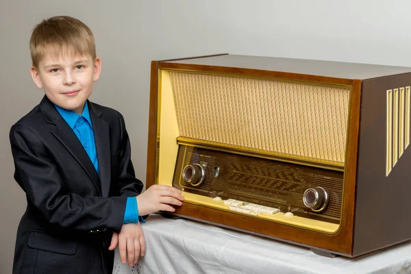 En lille dreng ved siden af den gamle radio . - Stock-foto