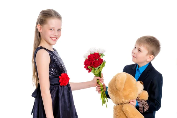 A little boy gives the girl flowers. — Stock Photo, Image