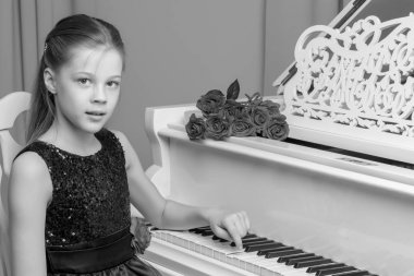 Küçük kız piyano, siyah ve beyaz fotoğraf çalış.