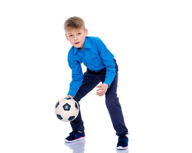 Küçük çocuk bir futbol topuyla oynuyor.