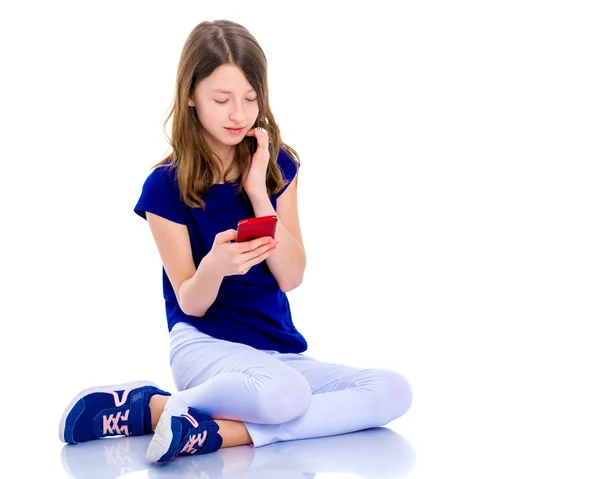 La chica está usando un teléfono celular . — Foto de Stock