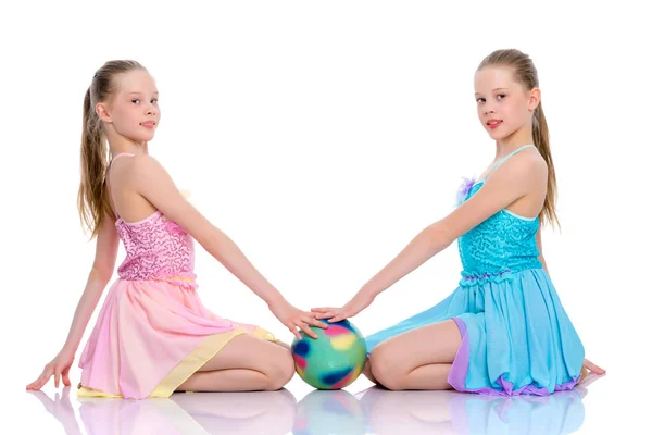 Meisjes gymnasten uitvoeren van oefeningen met de bal. — Stockfoto