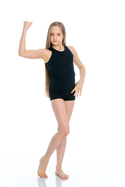 Chica gimnasta en una camiseta negra y pantalones cortos se preparan para el ejercicio — Foto de Stock