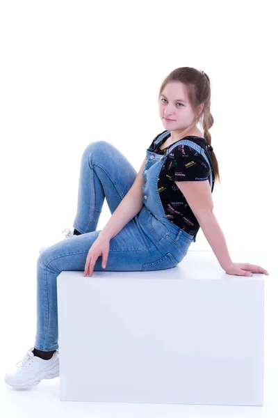 Adolescente chica posando estudio en un cubo blanco . — Foto de Stock