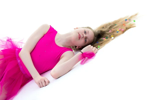 Uma ginasta menina bonito da idade escolar está deitado no chão com lon — Fotografia de Stock