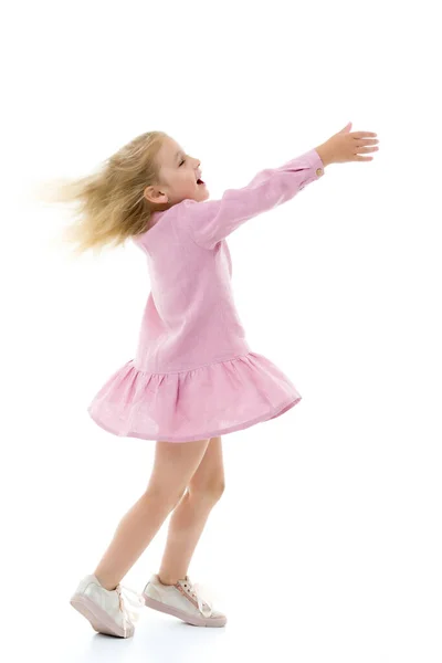 A little girl in a dress is spinning. Stock Image