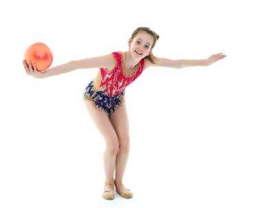Kız jimnastikçi, topla egzersiz yapıyor..