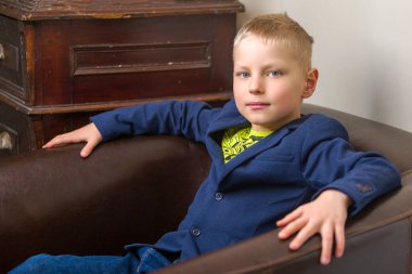 Küçük şirin bir çocuk sandalyede oturuyor..