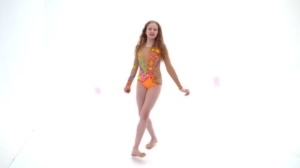 Een meisje gymnast voert oefeningen met een knots. — Stockvideo