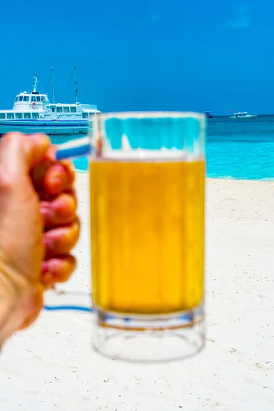 A glass of beer with Beautiful tropical Maldives island