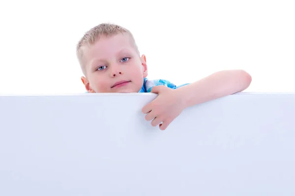 Un niño pequeño está mirando detrás de una pancarta vacía . —  Fotos de Stock