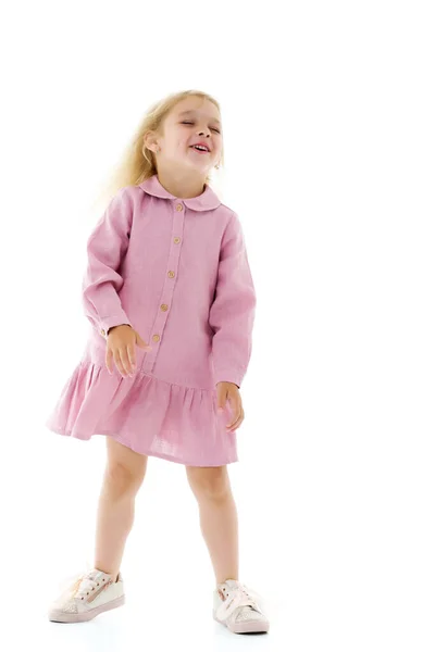 Een klein meisje in een jurk draait.. — Stockfoto