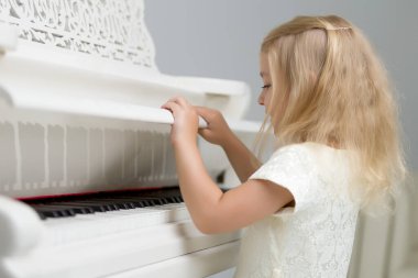 Kız beyaz piyanonun başında..