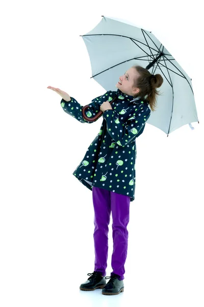 La niña se escondió bajo un paraguas y extendió su mano. El — Foto de Stock