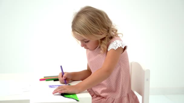 Una niña está dibujando en la mesa. . — Vídeo de stock