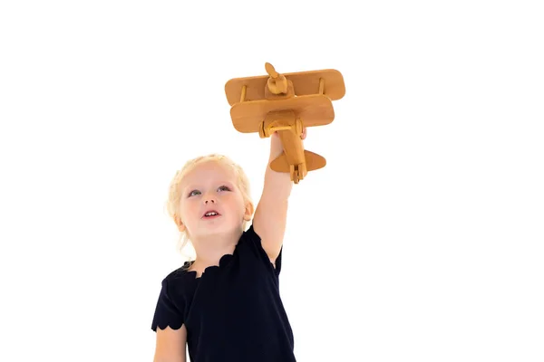 La bambina sta giocando con un aereo di legno. — Foto Stock