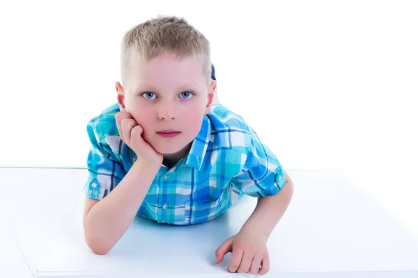 Un beau petit garçon est photographié près d'un cube blanc. Le co — Photo