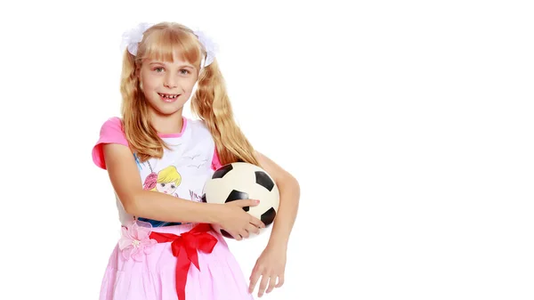 Niña con una pelota de futbol. El concepto de deportes infantiles . — Foto de Stock