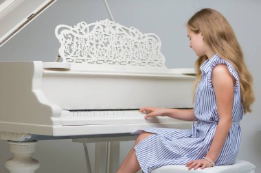 Kız beyaz piyanonun başında..