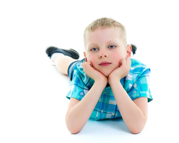 Ragazzino felice è sdraiato sul pavimento in studio . — Foto Stock