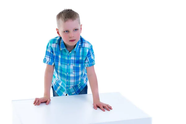 Un beau petit garçon est photographié près d'un cube blanc. Le co — Photo