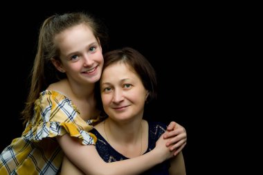 Anne ve küçük kız stüdyo resmi. Siyah arka planda.