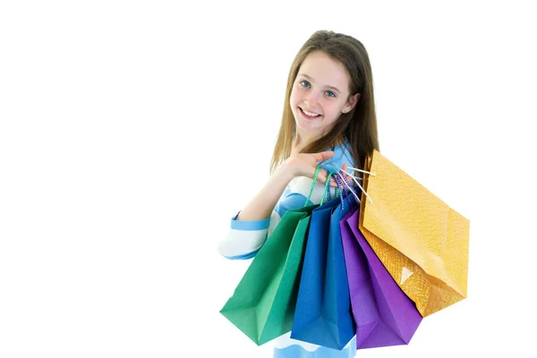 Tiener meisje winkelen in een winkel met grote papieren tassen. — Stockfoto