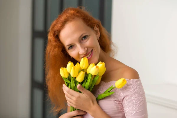 Gelukkige jonge vrouw met een boeket bloemen. Studio portret. — Stockfoto