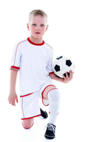 Een kleine jongen die het dragen van een puur wit t-shirt rommelt met een socc — Stockfoto