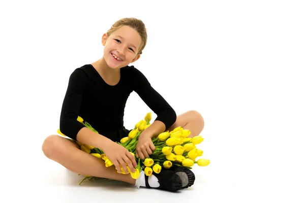 Güzel küçük kız jimnastikçi, elinde bir buket çiçekle... — Stok fotoğraf