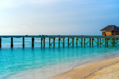 Tropikal kıyılarında kulübelere giden ahşap köprüler