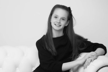 Güzel genç kız şöminenin yanındaki kanepede oturuyor.