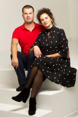 Mutlu genç çift evlerinin merdivenlerinde oturuyor.