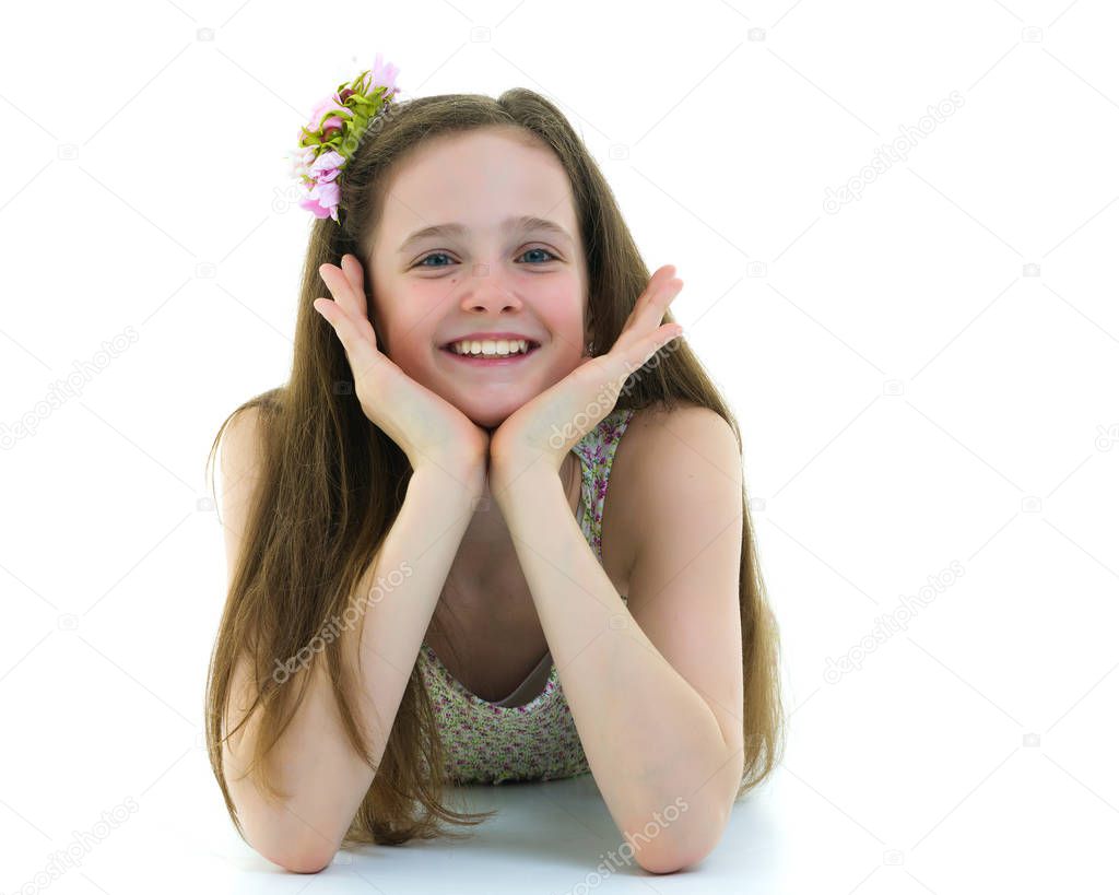 A teenage girl lies on the floor.Studio photo shoot on a white b