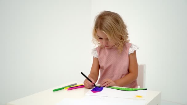 Egy kislány az asztalnál a rajz. — Stock videók