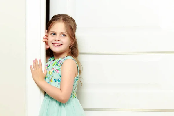 Una niña está parada junto a la puerta. . —  Fotos de Stock