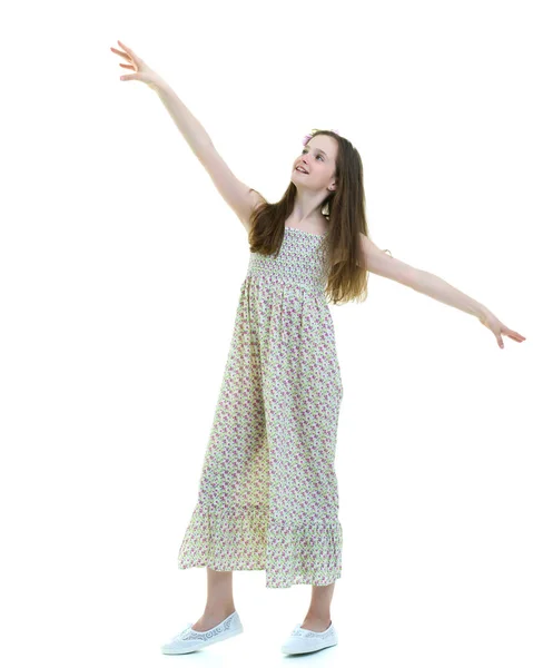 Een mooi klein meisje staat in de wind, haar haar en kleren — Stockfoto