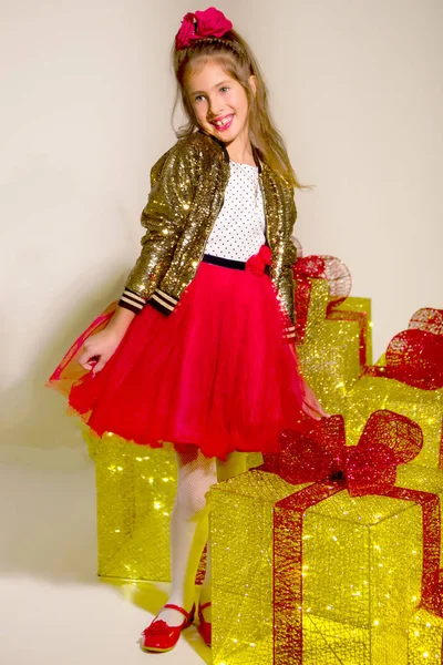 Piccola ragazza carina guardando all'interno della scatola regalo di Natale incandescente — Foto Stock