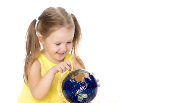 A little girl looks at the Globe. — Stock Photo, Image