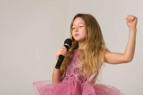 Caucasian children singing karaoke on a white background