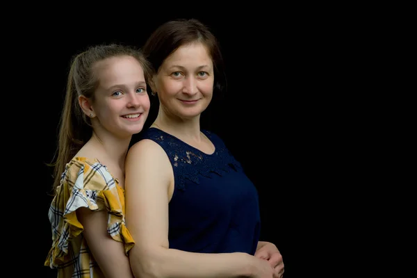 Máma a dcera ve studiu na černém pozadí. — Stock fotografie