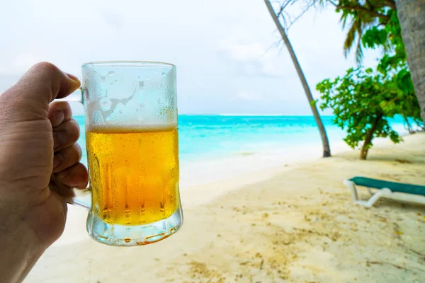 A glass of beer with Beautiful tropical Maldives island