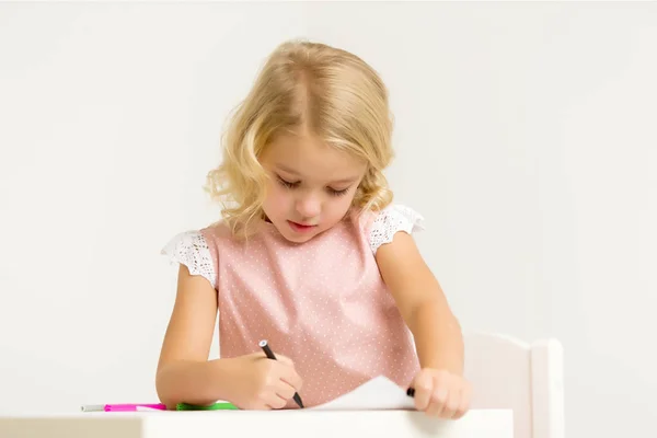 Une petite fille dessine à la table . — Photo