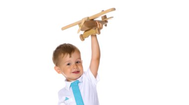 Küçük çocuk tahta uçakla oynuyor.