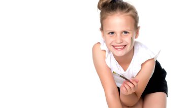 Küçük bir kız boyalar vücudunda çizer.