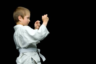 Beyaz kimonolu küçük bir çocuk darbeleri yerine getirsin.