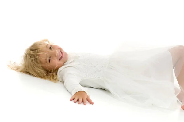 Petite fille se trouve sur le plancher.Studio séance photo sur un dos blanc — Photo